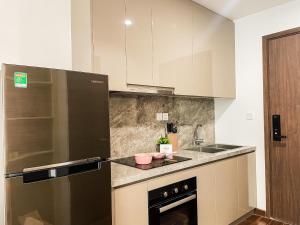 uma cozinha com um frigorífico de aço inoxidável e um lavatório em SISO homestay - Enchanting Studio em Hanói