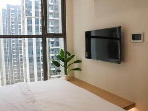 een slaapkamer met een bed en een flatscreen-tv bij SISO homestay - Enchanting Studio in Hanoi