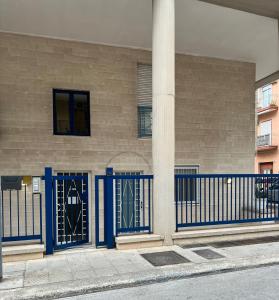 a building with blue gates on the side of it at Casa Nicola Maria in Grottaglie