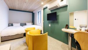 北見市にあるTabist MEN‘TEL Kitamiのベッド、デスク、椅子が備わるホテルルームです。