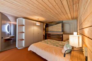 a bedroom with a bed and a wooden ceiling at le petit ballon in Ventron