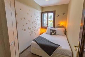1 dormitorio con cama y ventana con pájaros en la pared en Apartament el Cabirol, en La Molina