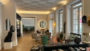 uma sala de estar com um sofá e uma mesa em Logis Hôtel Restaurant Grand Hôtel de Lyon em Vals-les-Bains