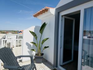 einen Balkon mit zwei Stühlen und einer Pflanze in der Unterkunft Sea & Sun Hospedaria Recomeçar in Torres Vedras