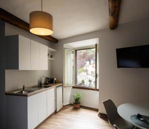 a kitchen with a sink and a table and a window at Alloggio turistico All'Ombra della Torre in Viterbo