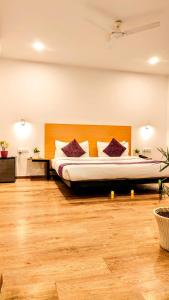 um quarto com uma cama grande e almofadas roxas em Mavens White Artemis Hospital Road Sector 52 Gurgaon em Gurgaon