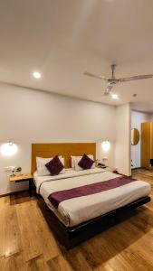 グルガオンにあるMavens White Artemis Hospital Road Sector 52 Gurgaonのベッドルーム1室(大型ベッド1台、紫色の枕付)