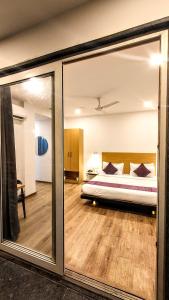 een slaapkamer met een bed en een grote spiegel bij Mavens White Artemis Hospital Road Sector 52 Gurgaon in Gurgaon