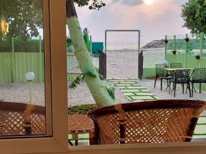 een raam met uitzicht op het strand bij Marari Eshban Beach Villa in Alleppey