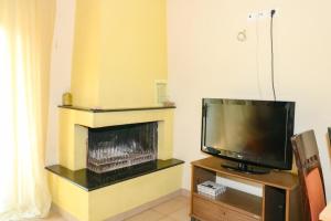 a living room with a tv and a fireplace at elia villa raches in Paralia Rachon