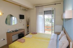a bedroom with a bed and a mirror and a window at elia villa raches in Paralia Rachon