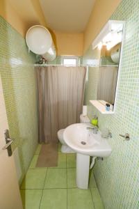 a bathroom with a sink and a toilet and a mirror at elia villa raches in Paralia Rachon