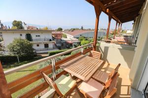 a balcony with a wooden table and chairs on it at elia villa raches in Paralia Rachon