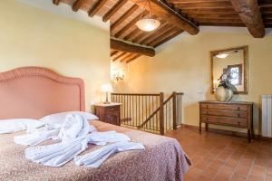 Un dormitorio con una cama con toallas blancas. en I Grandi Di Toscana, en Ciggiano