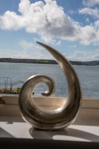 a metal sculpture in front of a window overlooking the water at Unit 2 Island View Apartments With Stunning Harbour View in Cobh