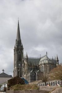 an old church with a tower and a clock at Unit 2 Island View Apartments With Stunning Harbour View in Cobh