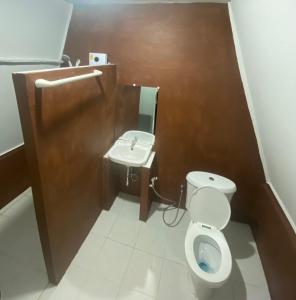 a bathroom with a toilet and a sink at คลองแสงฟาร์มสเตย์ in Ban Ta Khun