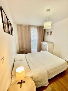 a bedroom with a large white bed and a window at Sweet Escape Paris Centre - 3 bds- terrasse - Stade de France - Montmartre in Saint-Ouen