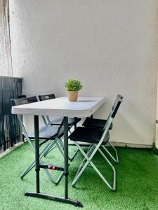 een tafel met twee stoelen en een potplant erop bij Sweet Escape Paris Centre - 3 bds- terrasse - Stade de France - Montmartre in Saint-Ouen