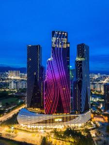 two tall buildings are lit up at night at Arte Mont Kiara By Awesomestay in Kuala Lumpur