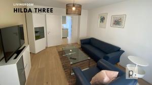 sala de estar con sofá azul y mesa de cristal en H3 with 3,5 rooms, 2 BR, livingroom and big kitchen, modern and central en Zúrich