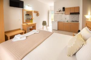 a bedroom with a white bed and a kitchen at House Elena in Koinyra