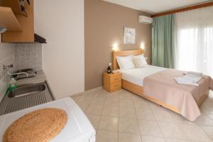 a bedroom with a bed and a sink and a kitchen at House Elena in Koinyra