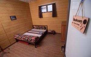 Habitación pequeña con cama y ventana en Mộc Mây Homestay, en Ha Giang