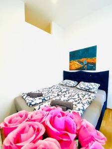 Zimmer mit einem Bett mit rosa Rosen darauf in der Unterkunft W Rooms - Brigittenau Area MM23 in Wien