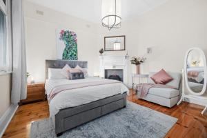 a bedroom with a bed and a couch and a fireplace at Mrs Percivals heritage luxury and romance with outdoor deep soak tub in Victor Harbor