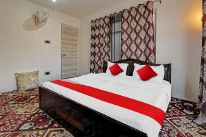 a bedroom with a large bed with red pillows at Eco Rooms in Jawāharnagar