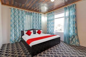 um quarto com uma cama com almofadas vermelhas e uma janela em Eco Rooms em Jawāharnagar