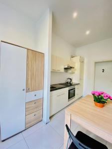 uma cozinha com armários brancos e uma mesa de madeira em W Rooms - Brigittenau Area MM23 em Viena