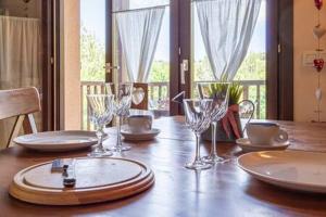 Una mesa de madera con platos y copas de vino encima. en Duplex la Solana, en Err