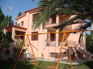 a house with a playground in front of it at Villa Angela in Sykia Chalkidikis