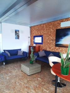 a living room with blue couches and a brick wall at Botel Diffuso dei Laghi in Porto Ceresio