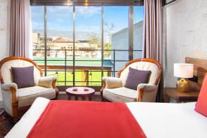 a bedroom with two chairs and a bed and a large window at Ayazma Cave Hotel in Ürgüp