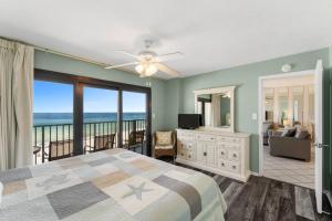 a bedroom with a bed and a view of the ocean at Commodore 504 in Panama City Beach