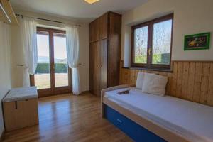 1 dormitorio con cama grande y ventana grande en Apartament les Costes del Cadí, en Estavar
