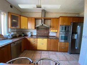a kitchen with wooden cabinets and stainless steel appliances at Espectacular ático dúplex con 2 terrazas & piscina in Málaga