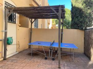 a blue ping pong table in front of a building at Espectacular ático dúplex con 2 terrazas & piscina in Málaga