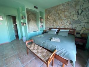 a bedroom with a large bed and a stone wall at Espectacular ático dúplex con 2 terrazas & piscina in Málaga +14 photos