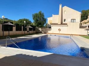 a swimming pool in front of a building at Espectacular ático dúplex con 2 terrazas & piscina in Málaga