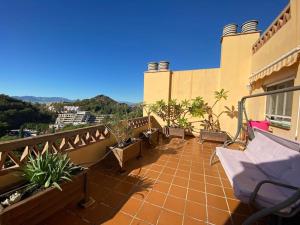 a balcony of a house with chairs and plants at Espectacular ático dúplex con 2 terrazas & piscina in Málaga