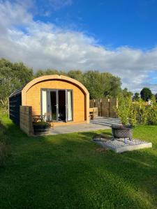 uma pequena casa de madeira num quintal com um pátio em Dwell on the Moor em Holme upon Spalding Moor