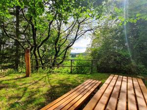 a wooden bench sitting in the grass near a fence at Ferienwohnung Landidylle in Birx