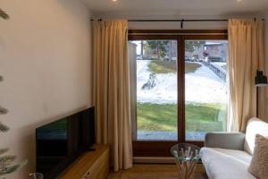 a living room with a couch and a large window at Apartament l'Osset in La Molina