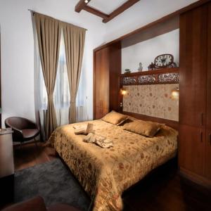 a bedroom with a large bed and a chair at Vinci Apartman Szombathely in Szombathely