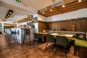 een restaurant met stoelen en een tafel en een bar bij The View - Design Panorama Lodge DAS SCHILLER in Bad Gastein