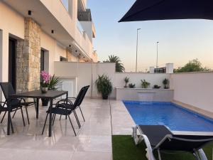 a patio with a table and chairs and a swimming pool at Villa avec piscine in Daya Vieja